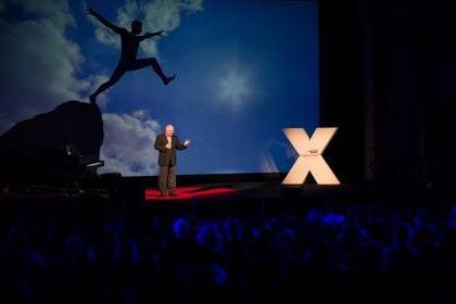 一位演讲者站在舞台上，在之前的TEDx活动在太平洋.