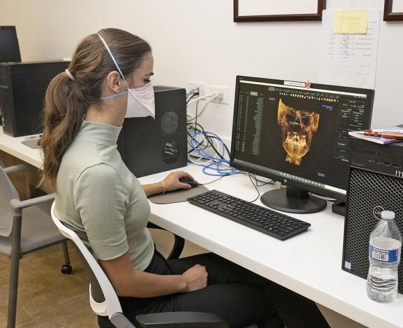 woman sitting at computer looking at orthodontics imaging